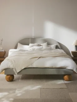 Cama tapizada con patas esfericas de madera Rena
